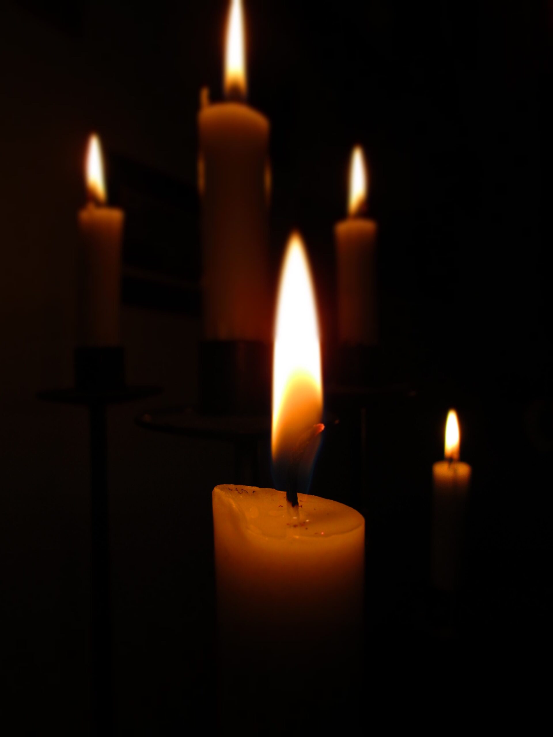 A serene image of glowing candles casting warm light in a dark room, perfect for cozy atmospheres.